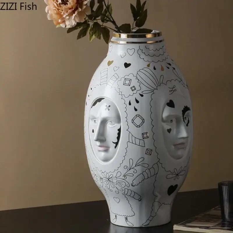 DecorBites™ ceramic vase desktop features a white ceramic vase with black line art faces and a gold rim for floral arrangements