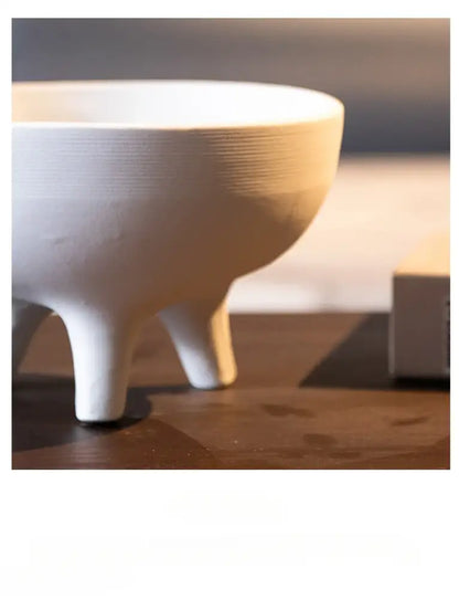 White ceramic flower pot from decorbites with subtle horizontal ridges and tripod stand for decorative use