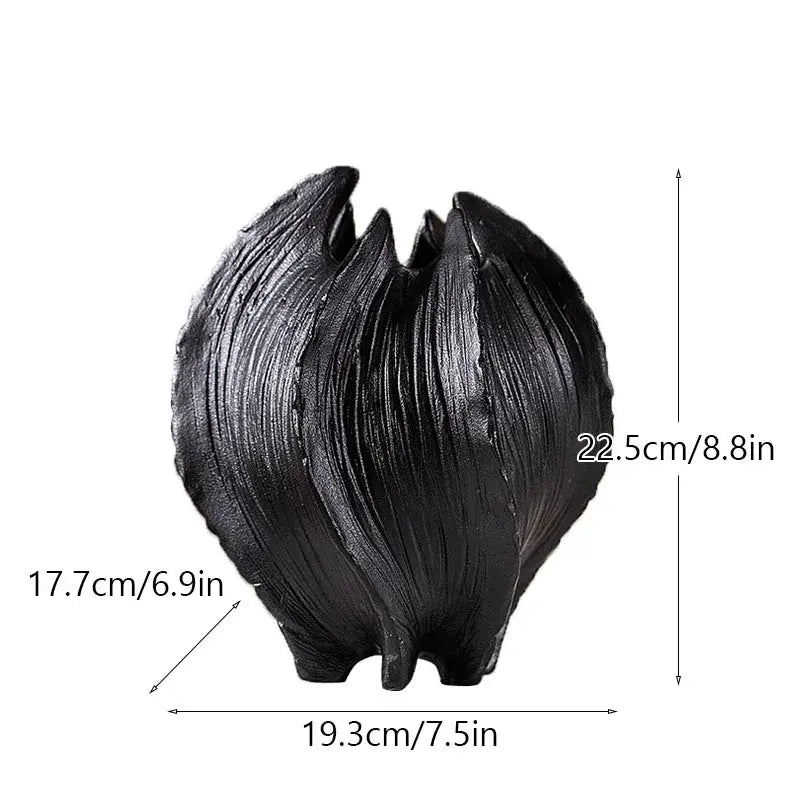 Black glossy ceramic sea vase with ridged texture and three pointed feet in nordic modern decor style