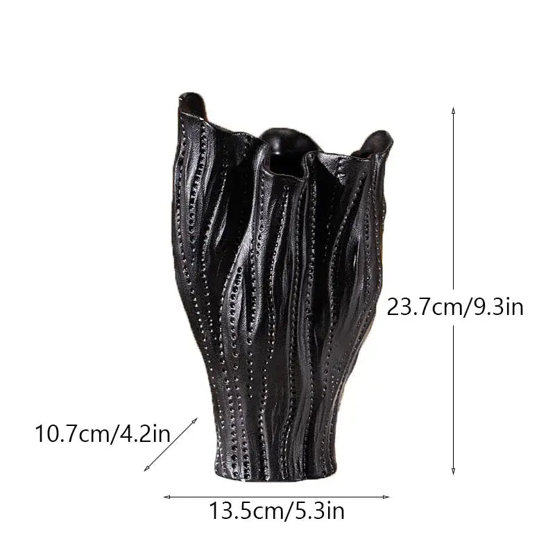 Black ceramic sea vase with textured leaf design and vertical dotted patterns in nordic modern decor style