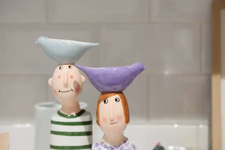 Decorbites ceramic vase set featuring a man and woman figurine each balancing a bird-shaped bowl in home decor