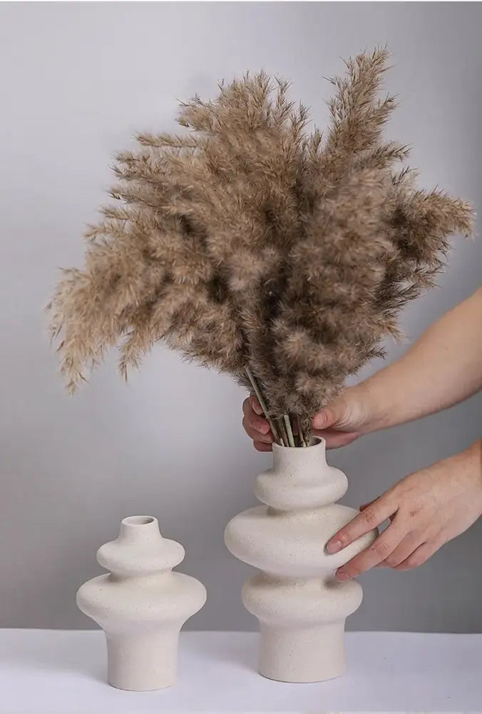 A beige ceramic vase from DecorBites™ with stacked organic design holding dried pampas grass for modern home decor