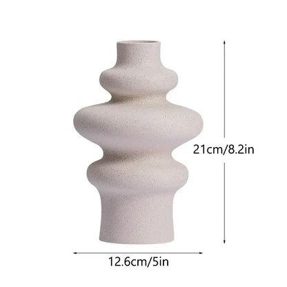 A sleek off-white ceramic vase with textured speckled finish and abstract tiered design ideal for modern home decor
