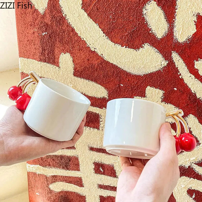 White ceramic DecorBites cherry handle mug with gold-toned cherry handle for tea and coffee on dining table