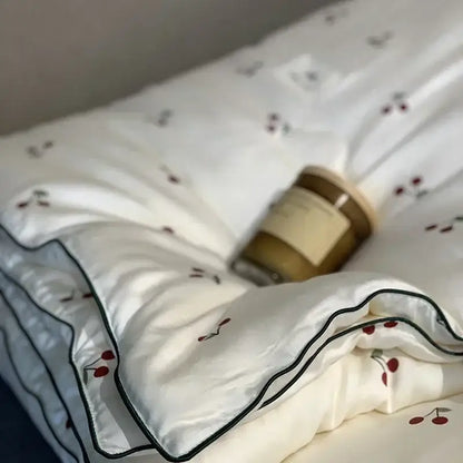 White silk DecorBites™ cherry lyocell fiber cooling duvet cover with red cherry embroidery and black piping