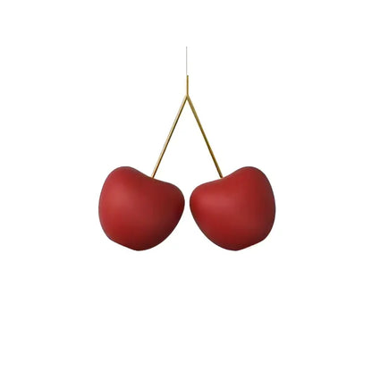 Red ceramic cherries hanging from gold stems in the decorbites cherry pendant lamp for modern home decor