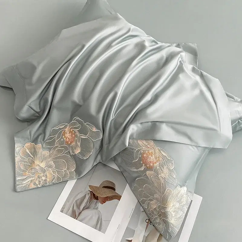 A soft light gray satin scarf with delicate gold and white floral embroidery complements decorbites chic embroidered cotton bedding set
