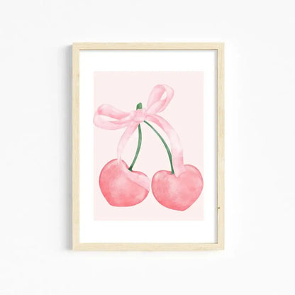 A framed watercolor print of two pink heart-shaped cherries tied with a pink ribbon bow for pink wall art