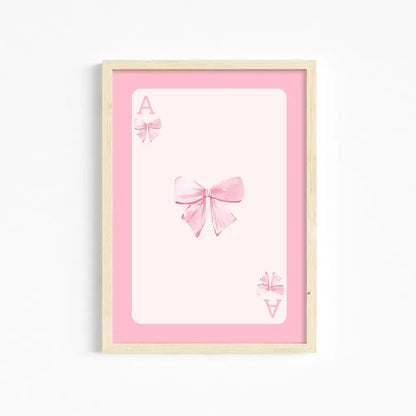 A framed pink and white ace card illustration with delicate bows pink wall art for girls room by DecorBites™