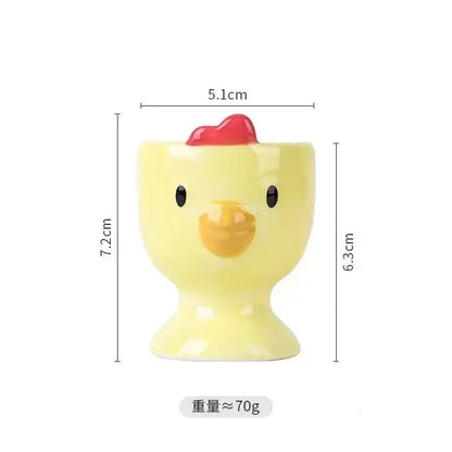 Yellow ceramic egg cup holder by DecorBites shaped like a chick with black eyes yellow beak and red comb for kids breakfast