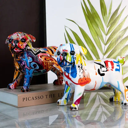 Two vibrant graffiti-style pug figurines featuring bold blue red yellow and black splash color art on glossy resin surfaces decorbites chihuahua splash statue