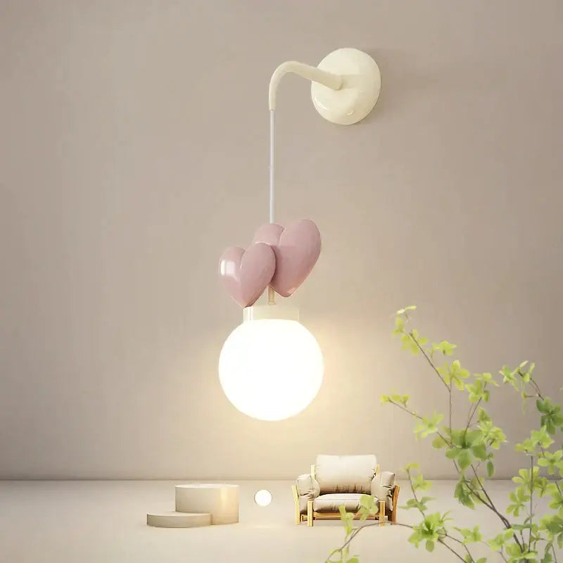 Pastel pink ceramic heart-shaped love wall lamp with white bulb and curved arm for nursery kids room decor by decorbites
