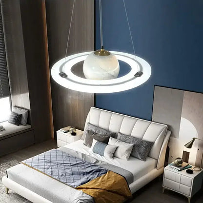 DecorBites™ children’s planet earth pendant lamp with white marble sphere and glowing acrylic rings above bed