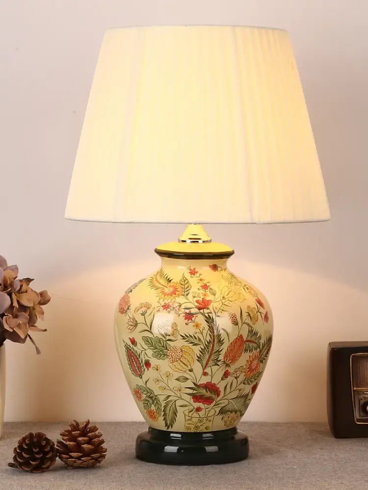 Cream-colored DecorBites™ bird flower ceramic table lamp with intricate floral patterns and pleated off-white shade