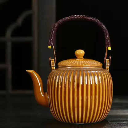 Glossy amber ceramic teapot set with vertical ridges dark purple woven handle and gold accents for puer tea brewing