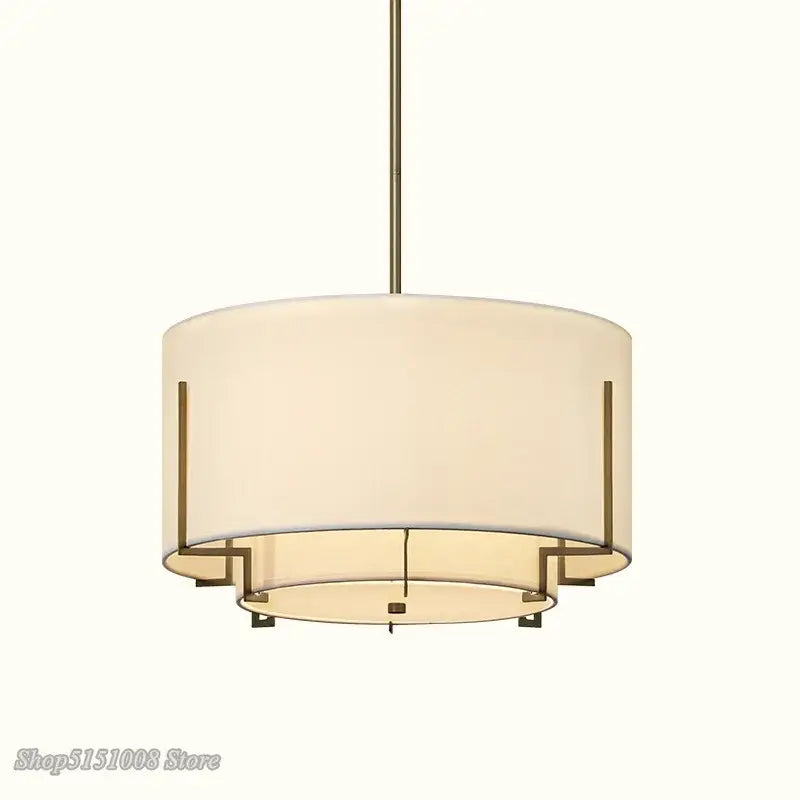 Modern minimalist living room pendant lamp with cream fabric shade and brass-toned metal drum frame by decorbites