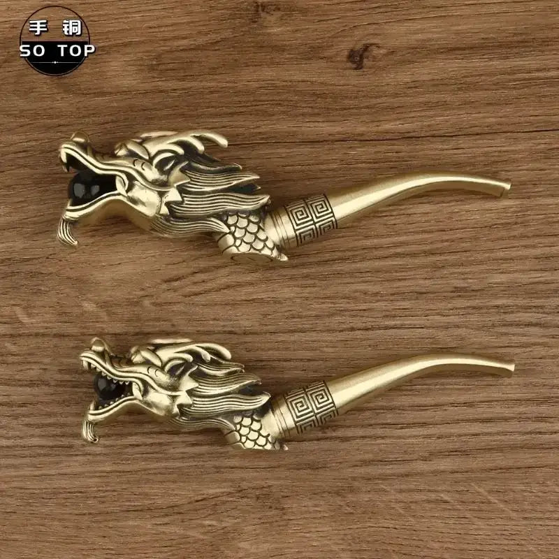 Two intricately crafted brass dragon-head copper filter pipes with detailed scale pattern and inlaid black stone eyes