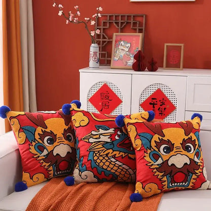 Vibrant red DecorBites™ dragon embroidered cushion cover with yellow blue embroidery and blue pom-poms for festive decor