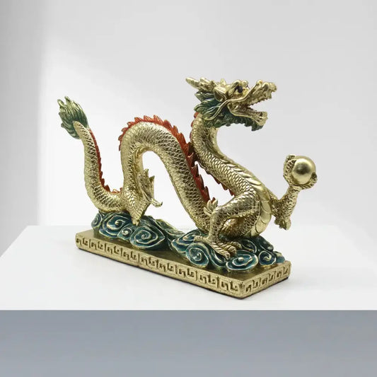 Golden resin sculpture of a decorbites chinese dragon with red and green accents and an ornate base for home decor