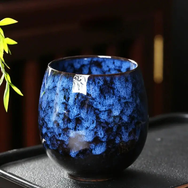A deep blue glossy ceramic coffee cup with a textured glaze and darkened base from the DecorBites™ coffee cup set