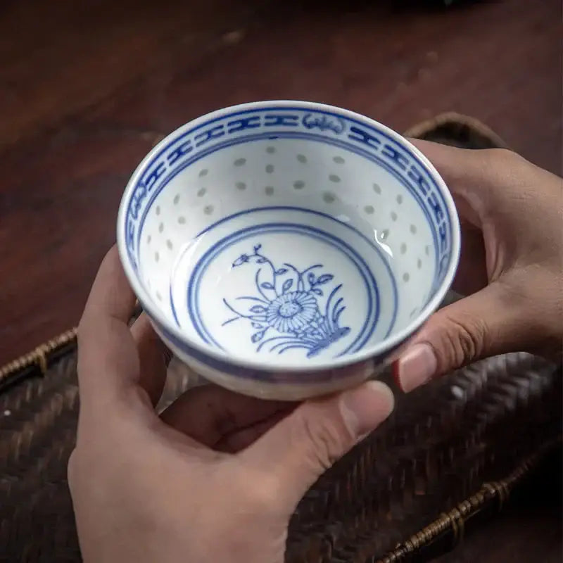 A delicate white porcelain orchid dragon bowl with intricate blue floral patterns and a perforated rim by decorbites chinese orchid