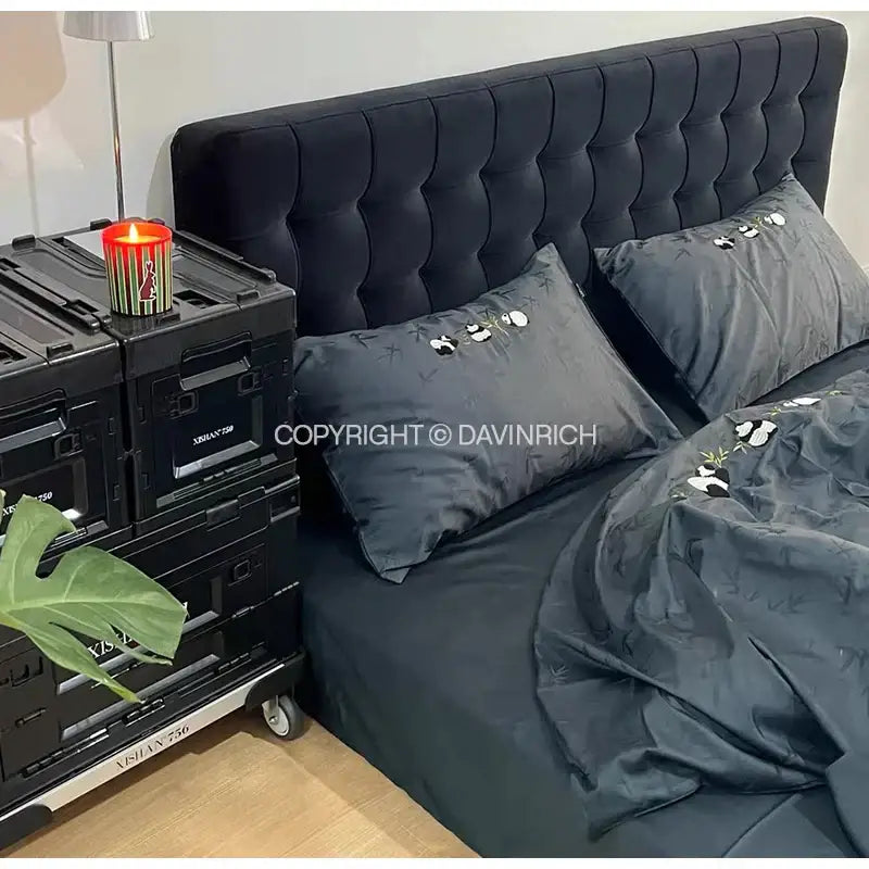 Black tufted velvet headboard with matching embroidered pillows and luxury bamboo jacquard duvet cover set