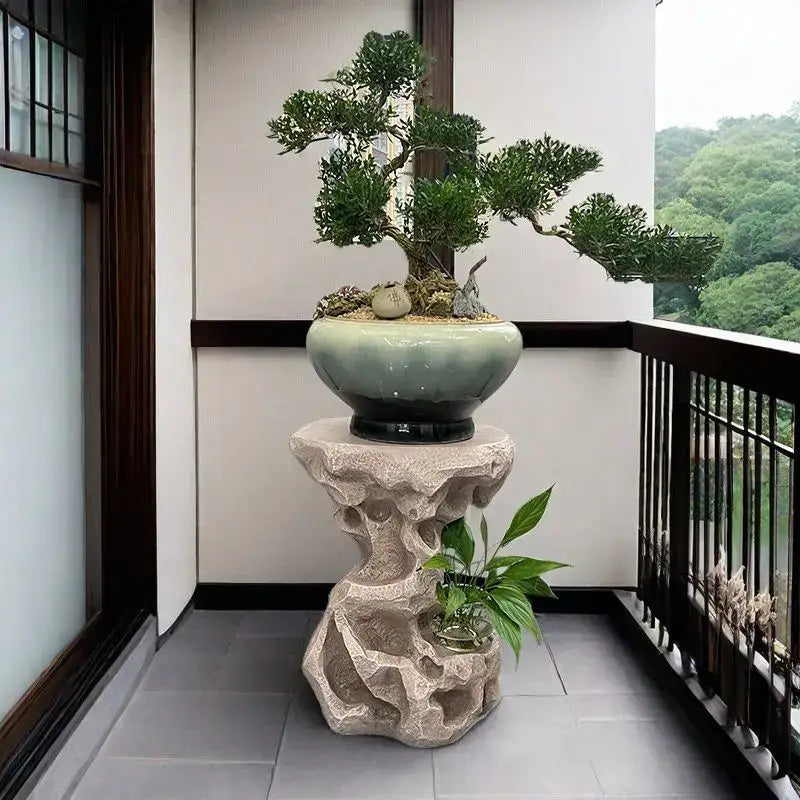 A serene green bonsai tree in a glazed ceramic pot on a carved stone pedestal for modern minimalist living room decor