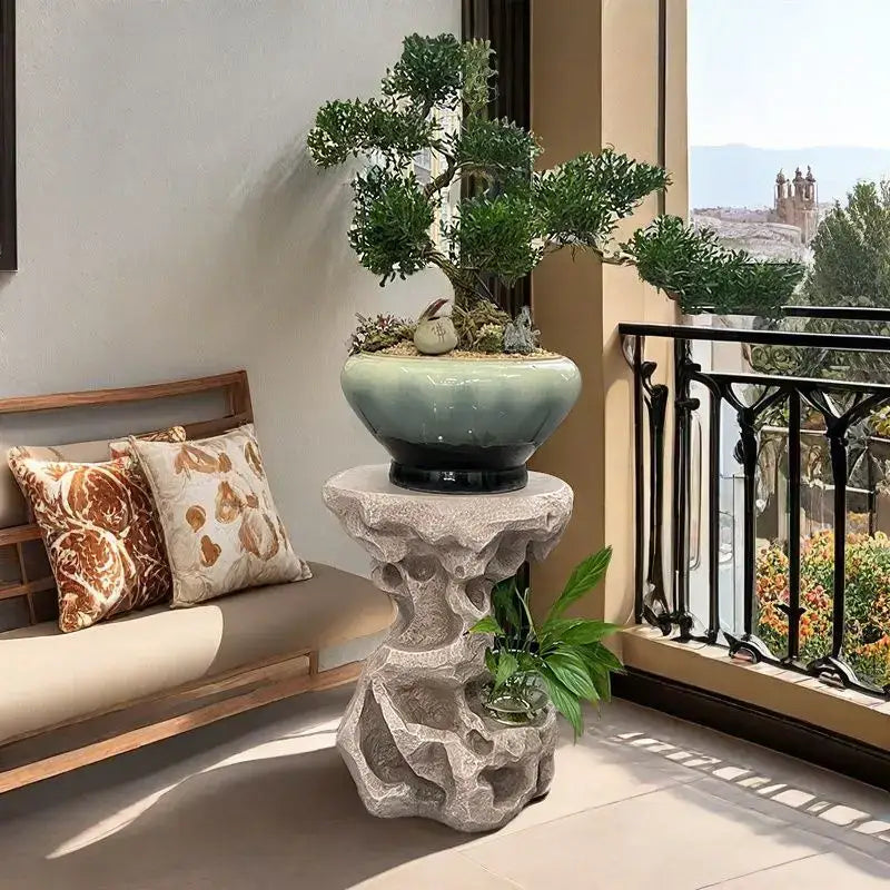 A ceramic bonsai tree in a light green glazed pot with black base on moss and stones for modern living room decor