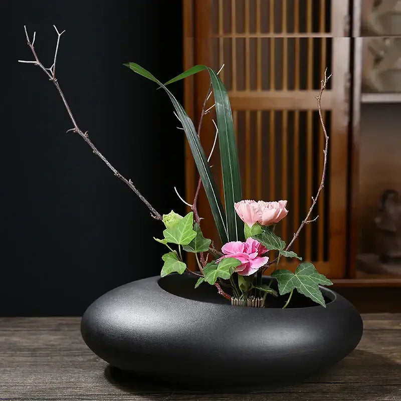 Black ceramic flowerpot vase with a minimalist floral arrangement for bonsai and home decor by DecorBites™