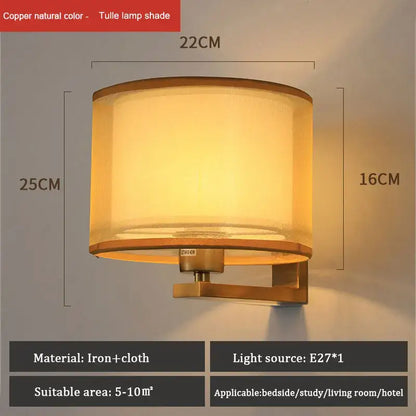DecorBites™ copper-finished cloth covered wall lamp with cylindrical tulle shade emitting warm light for bedroom use