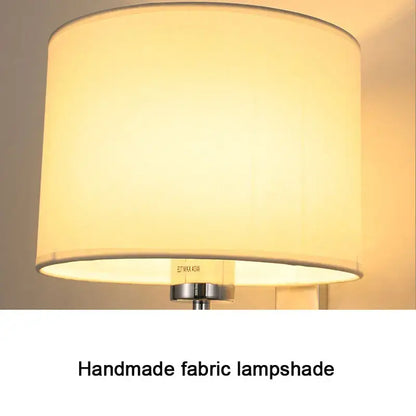 Cream-colored cylindrical fabric wall lamp with warm cloth cover and metallic base for bedroom living room use