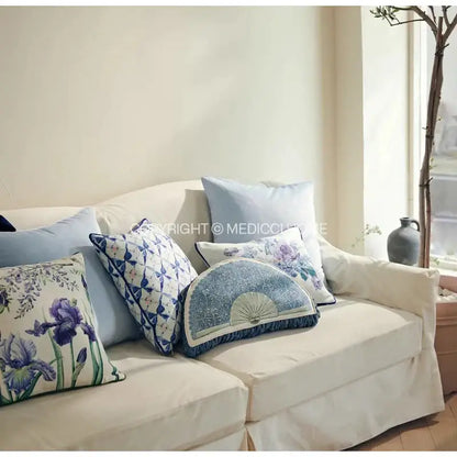 A soft cream-colored sofa with decorbites chinoiserie blue wavy fan pillowcase featuring intricate blue and white patterns