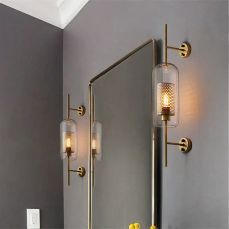 Decorbites chiswick glass wall light sconce with brass finish clear glass cylinder and perforated metal shade for home décor