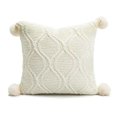 Cream-colored knitted throw pillow with cable-knit pattern and pom-poms from decorbites christmas candy cushions collection