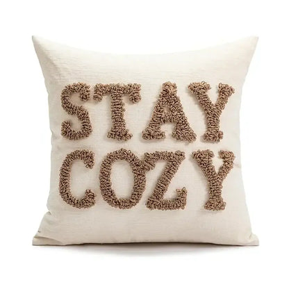 Cream-colored cushion cover with stay cozy embroidered in beige yarn for decorbites christmas cartoon candy design
