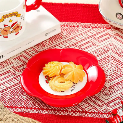 Red ceramic plate with scalloped edge and white center holding festive cookies from decorbites christmas ceramic santa tea set