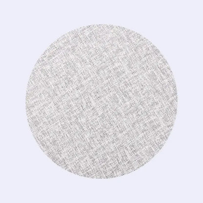A circular light gray textured fabric sample with subtle woven pattern for decorbites christmas decor placemat set