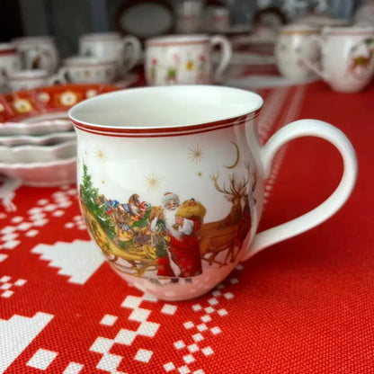 White ceramic mug with red rim featuring santa claus and reindeer in gold star decor from decorbites christmas dinnerware set