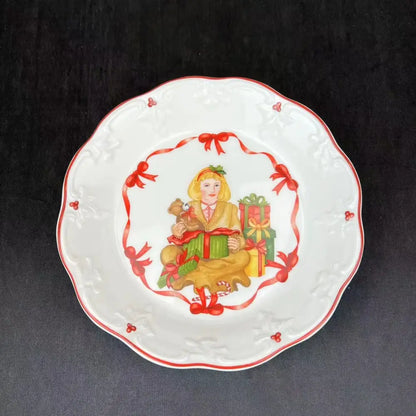 White ceramic plate with scalloped edges and red trim featuring a festive girl illustration for decorbites christmas dinnerware set