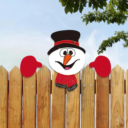 A cheerful cartoon snowman decoration with black top hat and red scarf peeking over a wooden fence in decorbites christmas door frame set