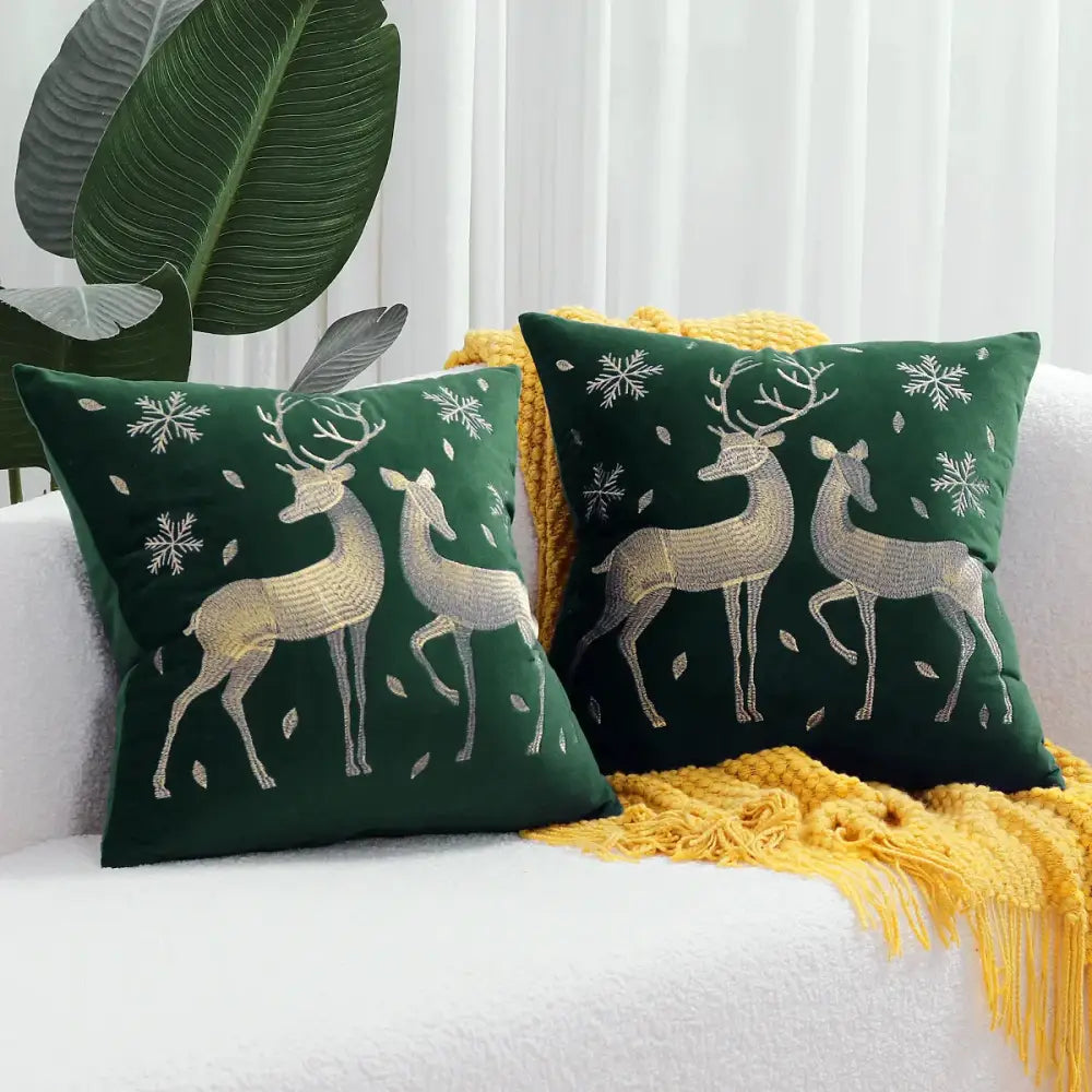 Deep green velvet pillow covers featuring decorbites christmas elk embroidered in metallic gold thread with snowflakes