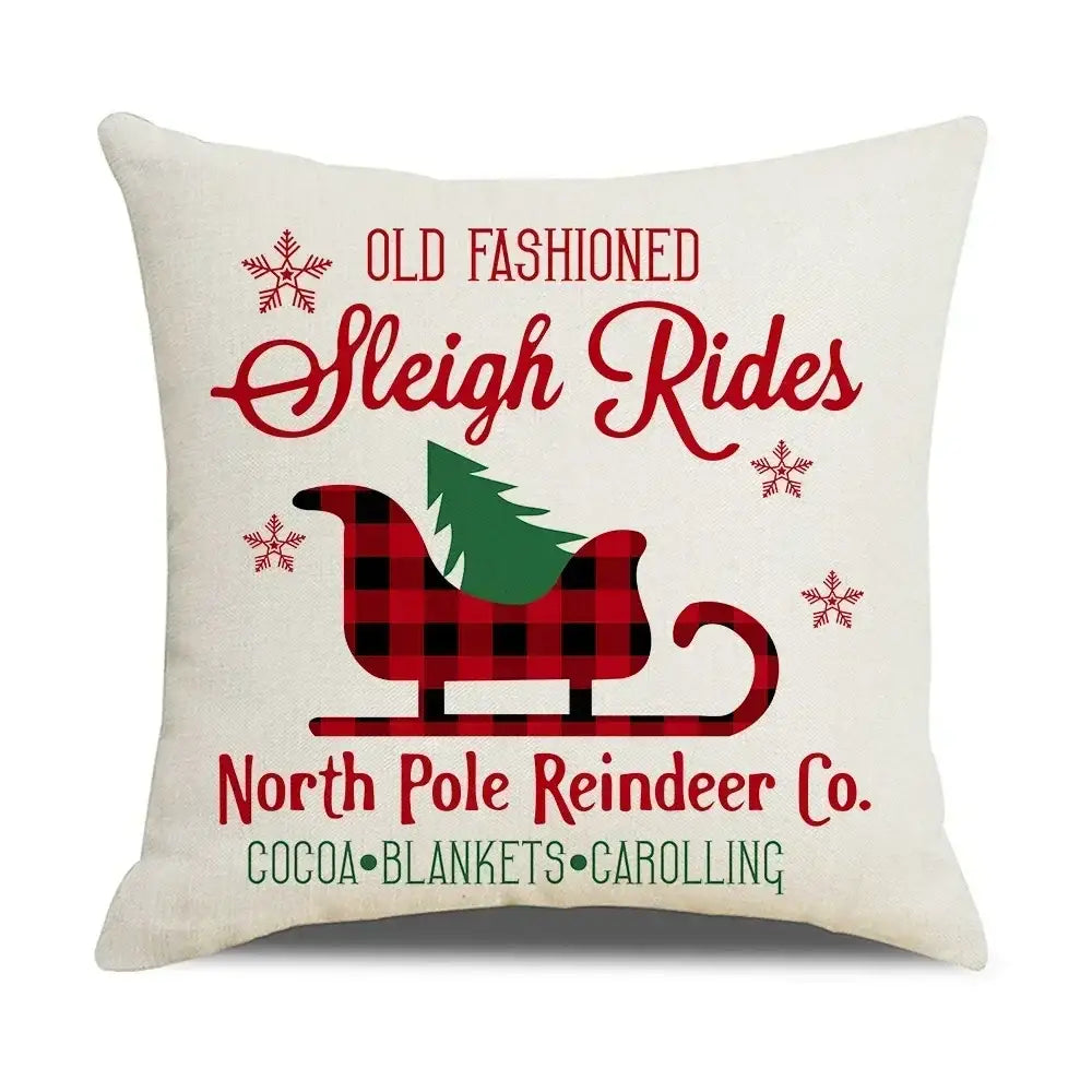 Cream-colored decorbites christmas elk throw pillow with red and black plaid sleigh and festive red letter design