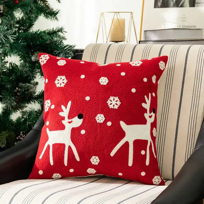 Red holiday pillow cover with white embroidered reindeer and snowflakes on plush fabric from decorbites christmas embroidered set