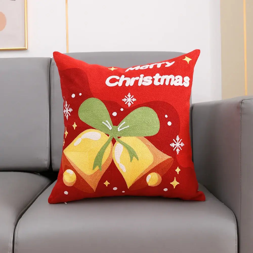 Red christmas-themed cushion cover with decorbites christmas embroidery in cotton featuring bells and festive motifs