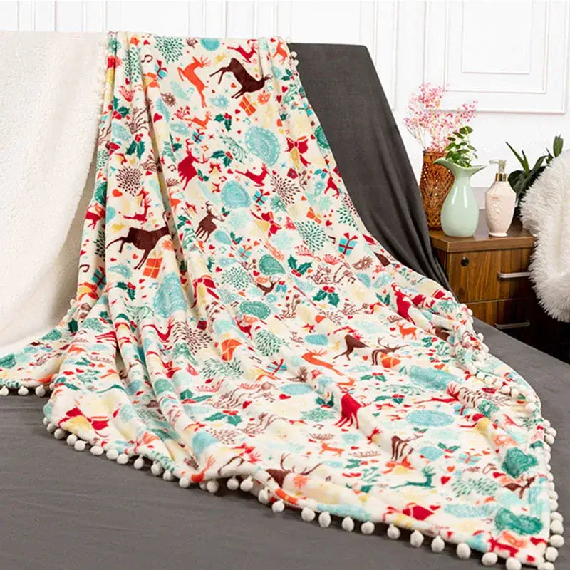 Decorbites christmas flannel cream plush blanket with festive reindeer pattern and white pom-pom edging for winter use