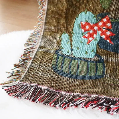 A cozy olive-green woven decorbites christmas holiday sofa blanket with turquoise cactus and multicolored fringe
