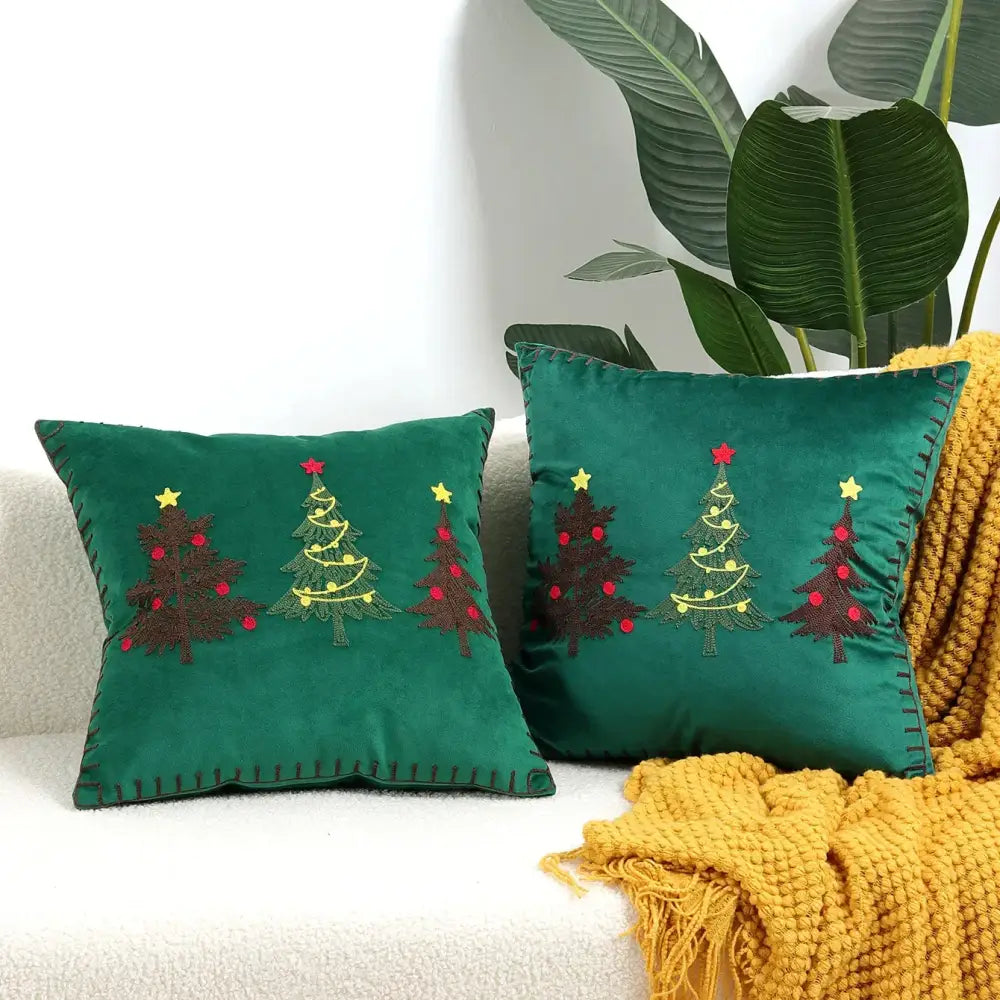 Emerald green velvet cushion cover with embroidered christmas trees featuring red ornaments and yellow stars by decorbites christmas patchwork merrychristmas