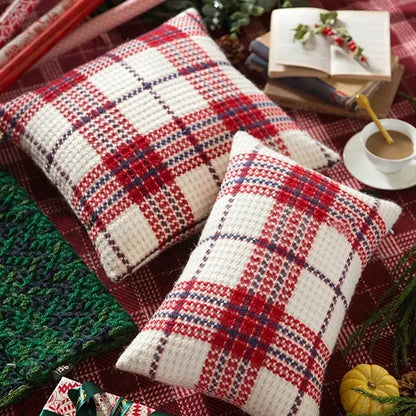 Two square knitted throw pillows with red and white christmas plaid weave cushion covers accented by navy blue lines