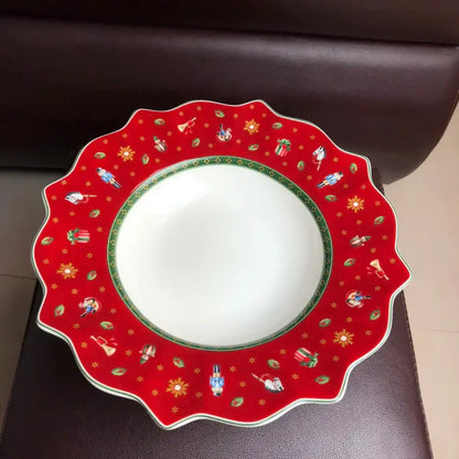 A festive red ceramic plate with scalloped edge featuring miniature nutcracker soldiers in decorbites christmas porcelain tableware set