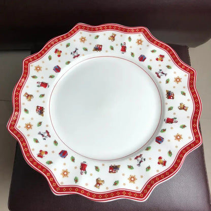 A festive white ceramic plate with scalloped edge and red gold christmas illustrations from the decorbites christmas porcelain tableware set